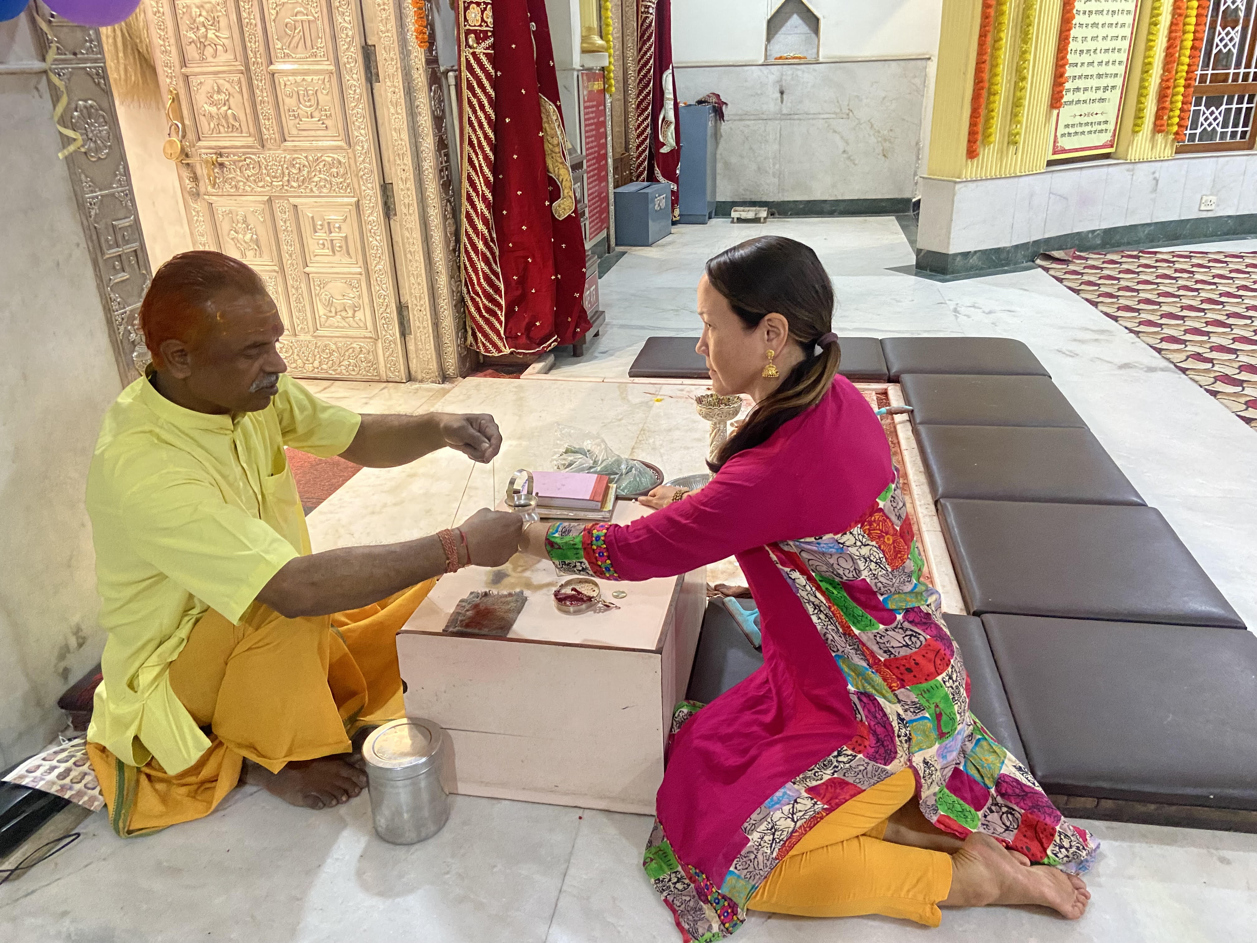 A priest blessing by tying a protection band “mauli” in Taala, Chhattisgarh